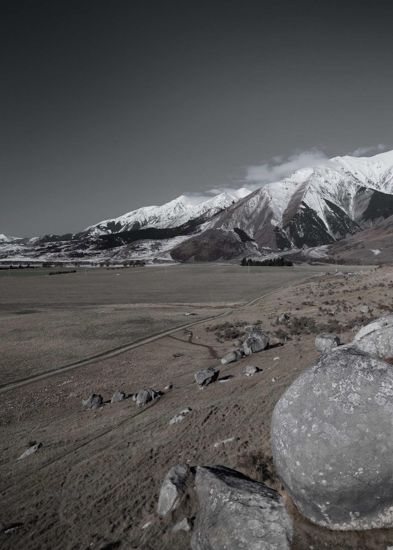 A mountain range rising above open country