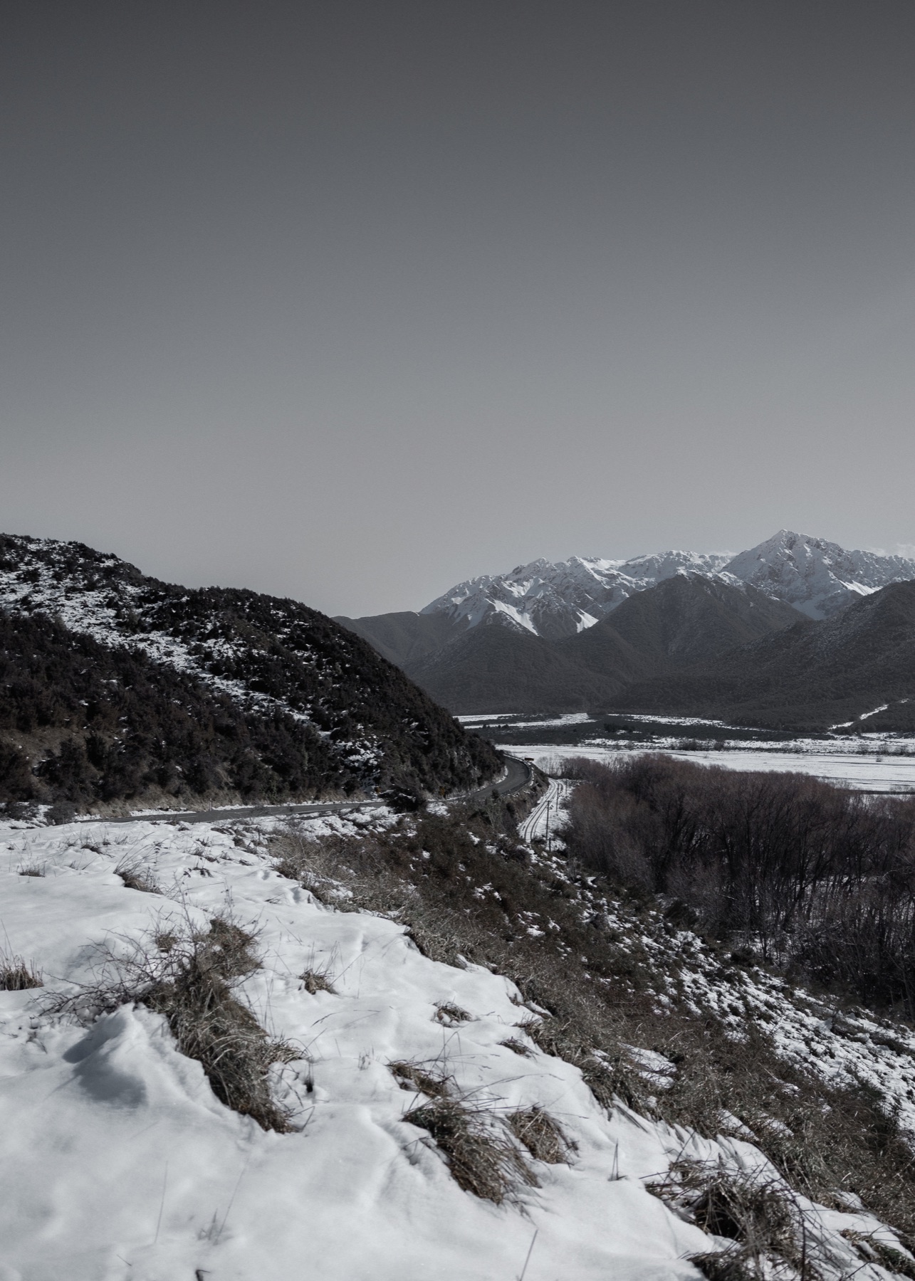 Snowy mountain road winding through a valley